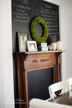 a chalkboard with a wreath on it next to a fireplace