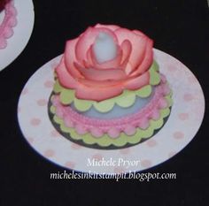 two cupcakes decorated with pink icing on top of white plates and black table cloth