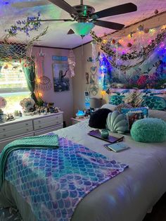 a bedroom with mermaid themed decor and lights on the ceiling