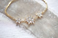 This delicate bridal bracelet features pretty crystal petals that effortlessly add a touch of shine to any look! - Bracelet has an adjustable slide clasp that will fit most wrist sizes - Available in rose gold, yellow gold and rhodium (silver) finishes - Handcrafted with high quality cubic zirconia Browse My Entire Shop For More Jewelry & Accessories: https://www.etsy.com/shop/TheExquisiteBride Browse My Shop For Earrings: https://www.etsy.com/shop/TheExquisiteBride?section_id=14483895 Brows Delicate Gold Bracelets For Wedding, Elegant Gold Crystal Bracelet For Wedding, Gold Cubic Zirconia Crystal Bracelet For Wedding, Elegant Gold Diamond Bracelet For Wedding, Gold Cubic Zirconia Wedding Bracelets, Dainty Cubic Zirconia Crystal Bracelet For Wedding, Delicate Gold Wedding Bracelet, Delicate Adjustable Gold Bracelet For Wedding, Dainty Adjustable Diamond Wedding Bracelet