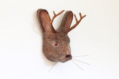 a wooden deer head mounted to the side of a wall