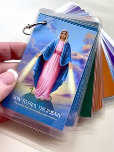 a hand holding a plastic card with the image of jesus on it in front of other cards