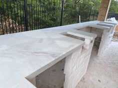 an outdoor kitchen with white marble counter tops