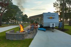 a camper trailer sitting next to a fire pit