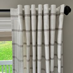 the curtains are hanging on the window sill in front of an open window with green grass