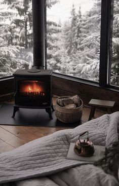 a bed in front of a large window with a fire place on top of it