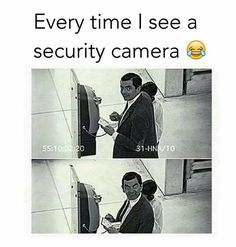 a man in suit and tie standing next to a tv with the caption every time i see a security camera