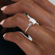 a woman's hand with a diamond ring on her finger and an engagement band