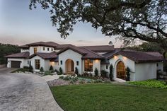 a large white house sitting next to a lush green field