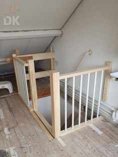 an unfinished room with wooden floors and white railings on the bottom floor is shown