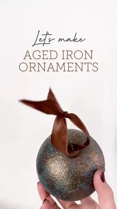 a person holding an object in their hand with the caption let's make aged iron ornaments