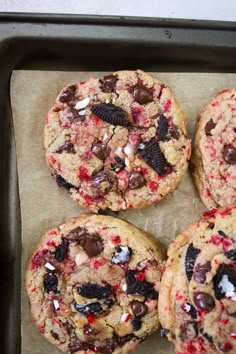 chocolate chip cookies with oreos and candy canes are on a baking sheet, ready to be eaten