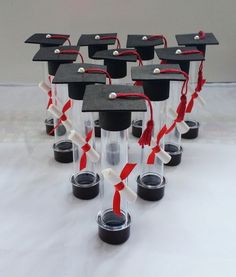 graduation caps and tassels are lined up in clear acrylic vases