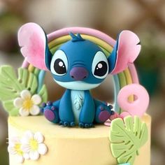 a blue and yellow cake with an elephant figurine on top