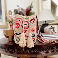 a purse sitting on top of a wooden table next to a lamp and bookcase