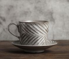 a cup and saucer sitting on top of a wooden table