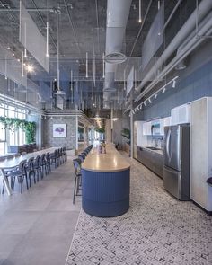 a large open kitchen and dining area with blue chairs in the center, along with an abundance of windows