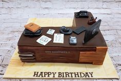 a birthday cake made to look like a desk with cell phones and books on it