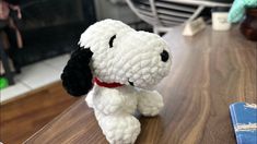 a white stuffed dog sitting on top of a wooden table