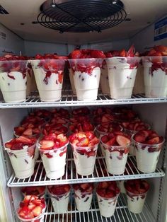 strawberries and yogurt in plastic cups on shelves