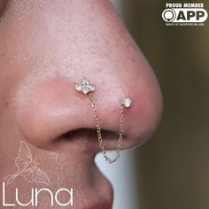 a close up of a person's nose with a chain attached to the nose