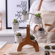 a person standing in front of a table with potted plants on top of it