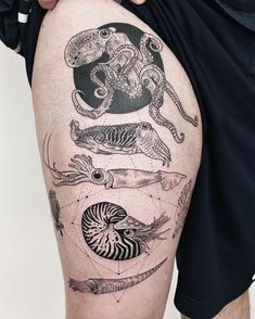 a man's thigh with tattoos on it and an image of fish, squid, octopus