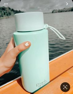 a person holding onto a water bottle on a boat