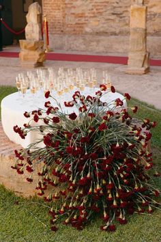 a bunch of wine glasses sitting on top of a table next to a flower arrangement