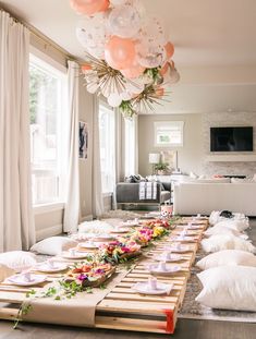 a long table is set up with plates and flowers on it for a party or celebration