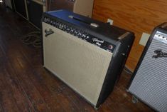 two amps sitting on the floor next to each other in a room with wood floors