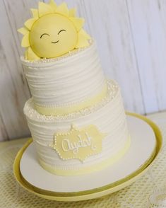 a white cake with yellow frosting and a smiling sun on top