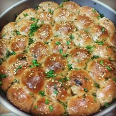 a pan filled with rolls covered in cheese and parsley