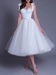 a woman is wearing a white dress with bows on her head and posing for the camera