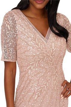 a woman wearing a pink dress with sequins on it