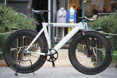 a white and black bicycle parked on the street