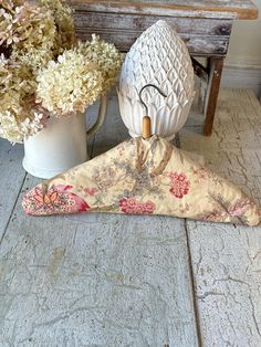 a vase with flowers sitting on top of a wooden table next to an owl figurine