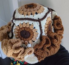 there is a crocheted sunflower on top of someone's hat,