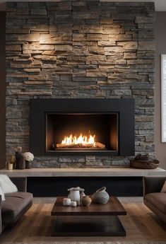 a living room with a fire place and couches in front of a stone wall