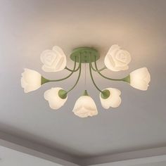 a green chandelier with white flowers hanging from it