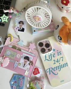 an assortment of personal items on a table next to a cell phone and keychain