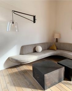 a living room filled with furniture on top of hard wood flooring next to a white wall