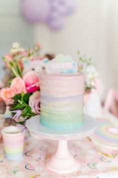 there is a cake on the table with pastel colors