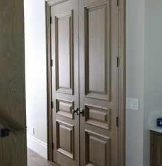 two wooden doors in a room with white walls