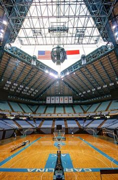 an indoor basketball court with lights on the ceiling