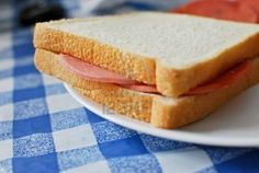 a close up of a sandwich on a plate with blue and white checkered table cloth