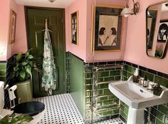 a bathroom with green and pink walls, black and white floor tiles and a sink