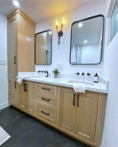 a bathroom with two sinks and mirrors on the wall