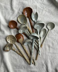 a bunch of spoons sitting on top of a white cloth