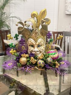 a mardi gras mask sitting on top of a glass table in a room